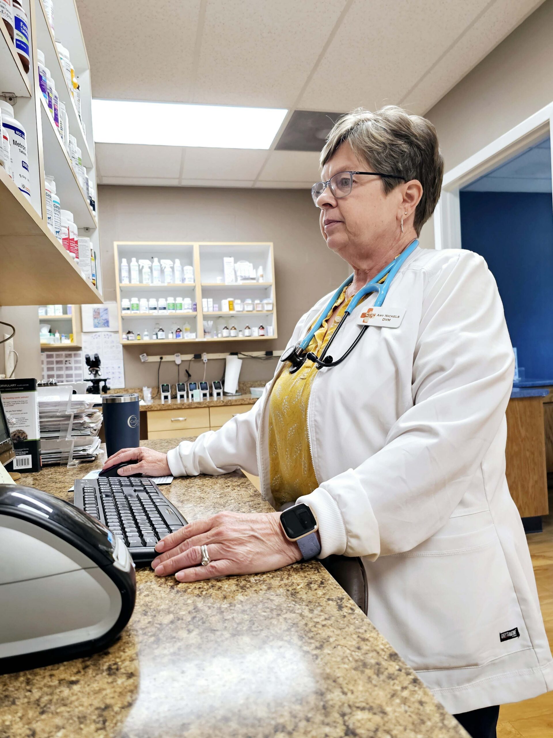 a vet in a white coat is working diligently at her desk